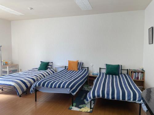甲府市にある富竹民泊のベッド3台が並ぶ客室です。