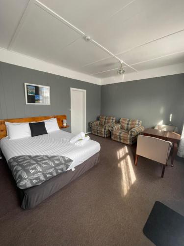a bedroom with a large bed and a couch at Mountain View Motel in Queenstown