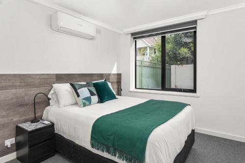 メルボルンにあるBoutique Stays - Lilly Pillyの大きなベッドと窓のある寝室