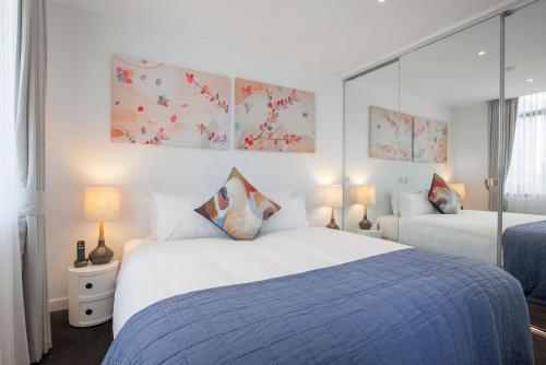 a bedroom with a large white bed and two lamps at Boutique Stays - Sea Breeze at Port in Melbourne
