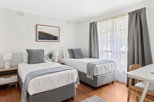 1 dormitorio con 2 camas y ventana en Boutique Stays - Flanders, en Melbourne