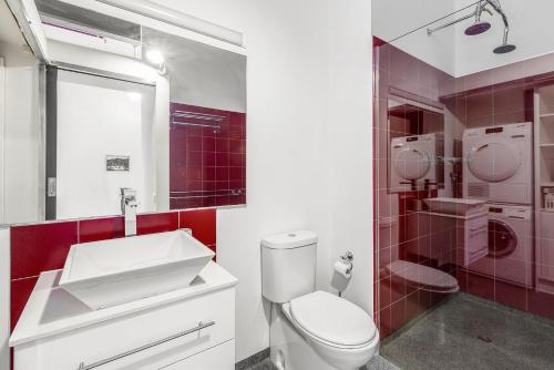 uma casa de banho com um WC branco e um lavatório. em Boutique Stays - Loft on Rose em Melbourne