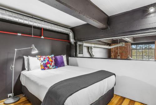 1 dormitorio con 1 cama grande en una habitación en Boutique Stays - Loft on Rose en Melbourne