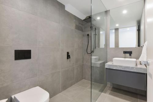 a bathroom with a shower and a toilet and a sink at Boutique Stays - Victoria Road in Melbourne