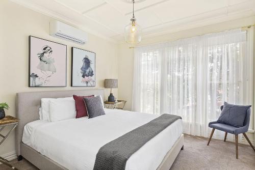 a bedroom with a large bed and a blue chair at Boutique Stays - Buckingham in Melbourne