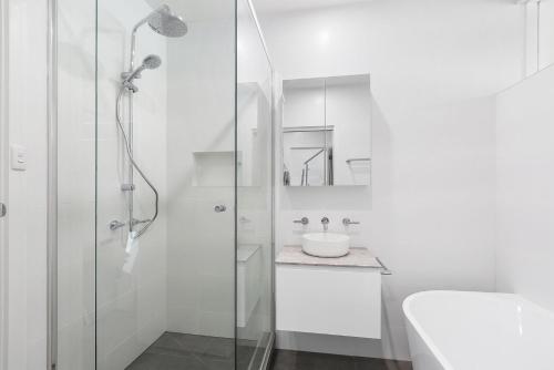 a white bathroom with a shower and a sink at Boutique Stays - Brighton By Sea in Melbourne