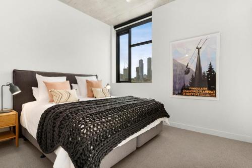 een slaapkamer met een groot bed en een groot raam bij Boutique Stays - Highviews in Melbourne