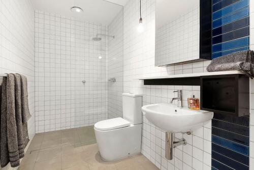 een witte badkamer met een toilet en een wastafel bij Boutique Stays - Highviews in Melbourne