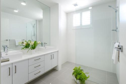 a white bathroom with two sinks and a shower at Boutique Stays - Hampton Lookout in Melbourne