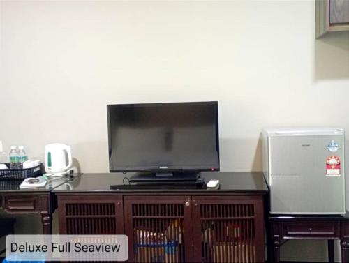 a television sitting on top of a wooden entertainment center at Alpine LXPD Full Seaview Water Chalet in Port Dickson