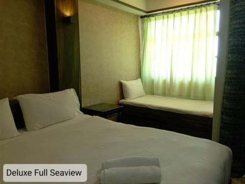 a hotel room with two beds and a window at Alpine LXPD Full Seaview Water Chalet in Port Dickson