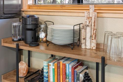 a shelf with a coffee maker and plates and books at Little House in the Big Woods in Forest Ranch