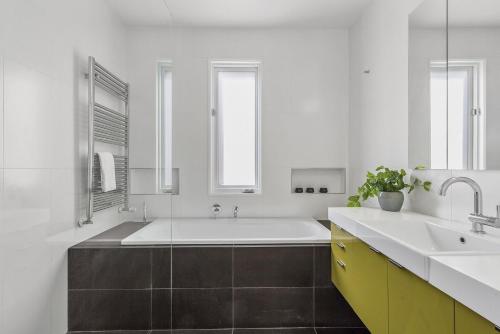 a white bathroom with a tub and a sink at Boutique Stays - Victorian Vogue in Melbourne