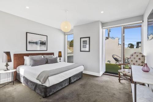 a bedroom with a bed and a large window at Boutique Stays - Victorian Vogue in Melbourne