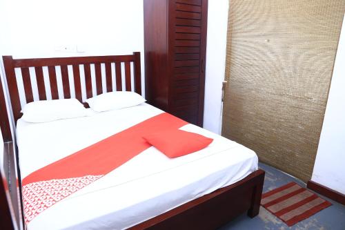 a bed with a red ribbon on top of it at Station Garden Hotel And Resturant in Jaffna
