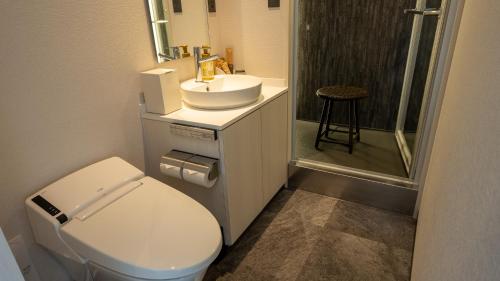 a bathroom with a toilet and a sink and a shower at THE HOTEL YAKUSHIMA ocean & forest in Yakushima