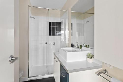 a white bathroom with a shower and a sink at Boutique Stays - Zinc Views 501 in Melbourne