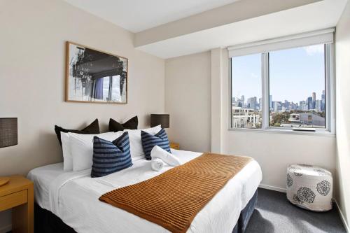 1 dormitorio con 1 cama grande y ventana grande en Boutique Stays - Zinc Views 501, en Melbourne