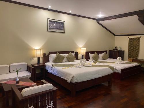 a hotel room with two beds and two chairs at Luang Prabang Residence & Travel in Luang Prabang