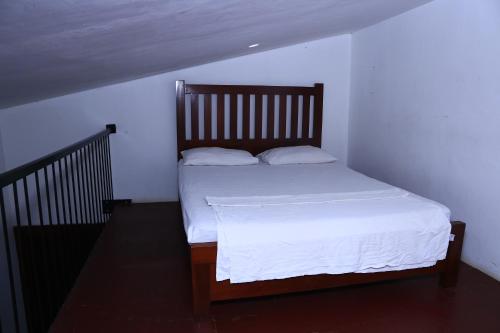 a bed with white sheets and pillows in a room at Station Garden Hotel And Resturant in Jaffna