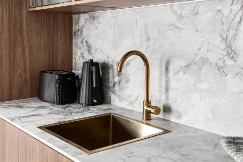 a kitchen counter with a sink and a sinkiterator at Boutique Stays - The Vault in Melbourne