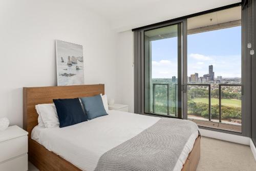 um quarto com uma cama e uma grande janela em Boutique Stays - Hazelle em Melbourne