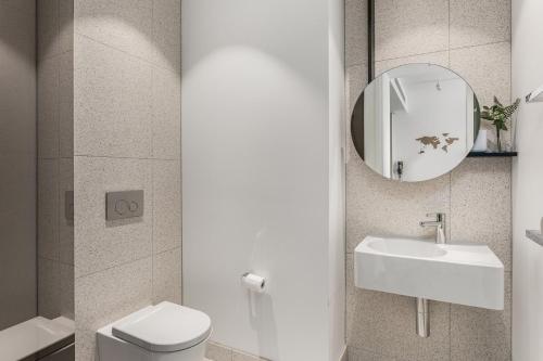 uma casa de banho com um WC, um lavatório e um espelho. em Boutique Stays - Hazelle em Melbourne