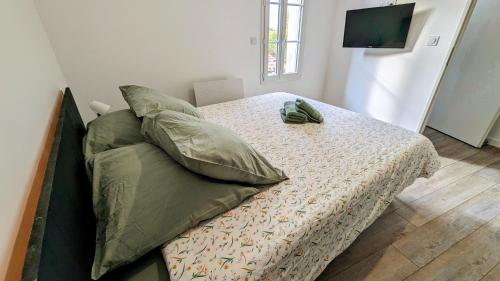 - un lit avec des oreillers verts dans l'établissement L'échoppe d'Elise (Gîte neuf), à Plassac