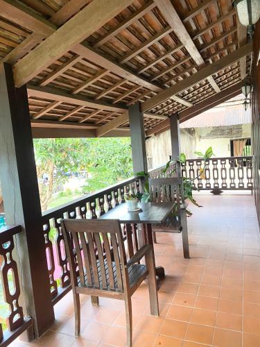 a porch with benches and a table on a balcony at Luang Prabang Residence & Travel in Luang Prabang