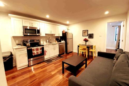 a living room with a couch and a kitchen at Modern Cozy Unit Near Geno's & Pat's in Philadelphia