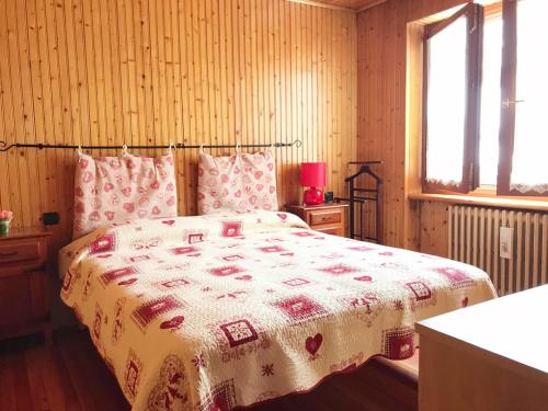 a bedroom with a bed with a red and white blanket at Il Pettirosso - Appartamento Panoramico con 3 Camere in Villetta in Champoluc