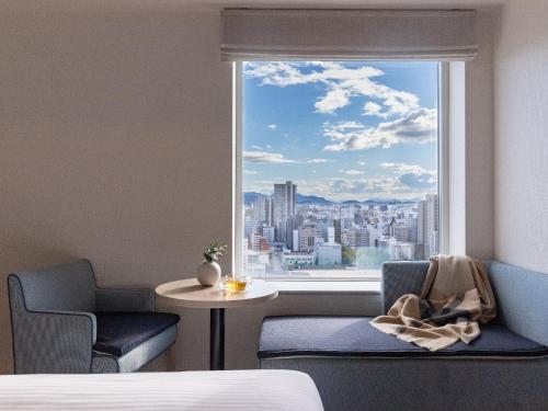 um quarto com uma janela com vista para a cidade em Mitsui Garden Hotel Hiroshima em Hiroshima