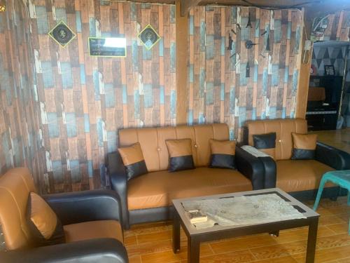 a living room with two couches and a table at Homestay Kurnia 