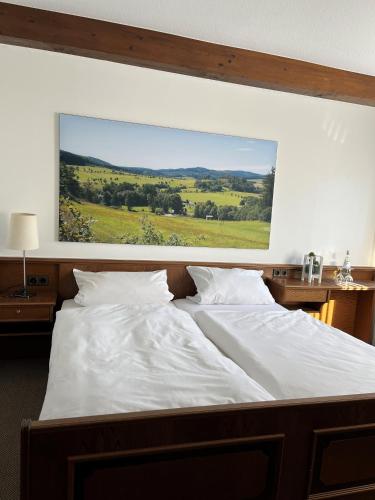 1 cama blanca grande con una pintura en la pared en Hotel Schnepper, en Attendorn