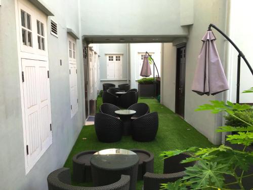 a room with chairs and tables on a green floor at Bliss Hotel Singapore in Singapore