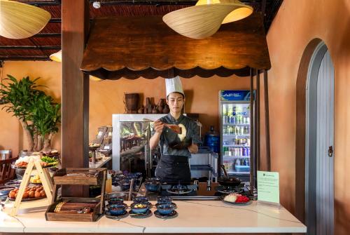 Das Spiegelbild eines Kochs hinter einer Theke in der Unterkunft Tam Coc Retreat Ninh Binh in Ninh Bình