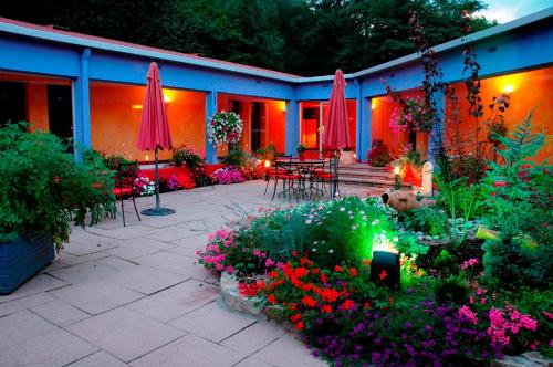 a patio with flowers and umbrellas in a garden at Logis Hôtel Atrium Epinal Golbey in Épinal