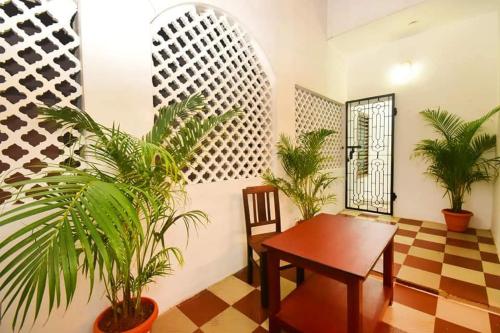 a dining room with a table and some plants at Villa Marinaa in Puducherry