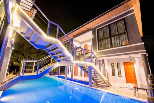 a house with a swimming pool with blue stairs at เเองเจล่า รีสอร์ท in Pran Buri
