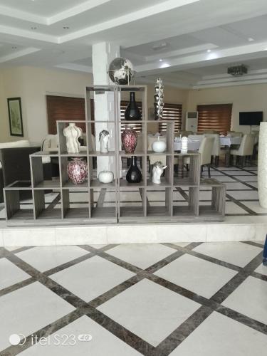 a room with a table with vases on shelves at Ellyxville Hotel in Lekki
