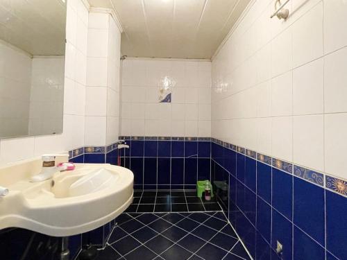 ein Bad mit einem Waschbecken und blauen und weißen Fliesen in der Unterkunft Seven Motel in Busan