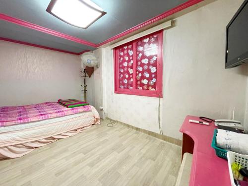 Kleines Zimmer mit einem Bett und einem Fenster in der Unterkunft Seven Motel in Busan