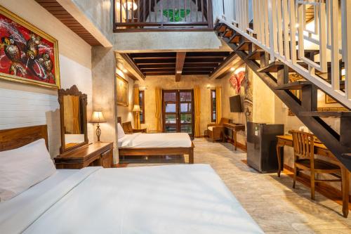 a bedroom with a bed and a staircase at Nirmala Guest House Surf Keramas in Keramas