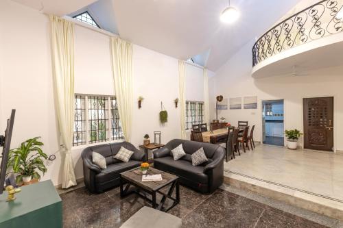 een woonkamer met een bank en een tafel bij Cozy 4BHK Villa in Bangalore