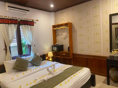 a bedroom with two beds and a mirror at Golden Lotus Place in Luang Prabang