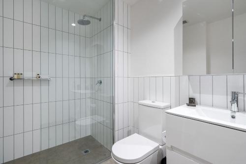 メルボルンにあるBoutique Stays - Axel Apartments 202 The Radnorの白いバスルーム(トイレ、シンク付)