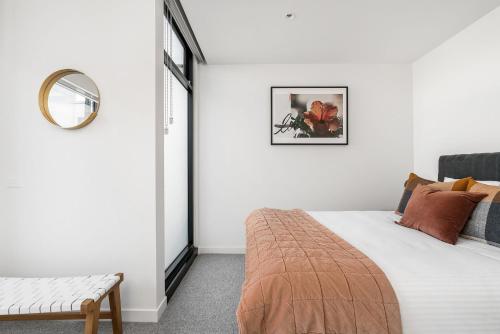 Habitación blanca con cama y espejo en Boutique Stays - Axel Apartments 203 The Bonfield en Melbourne