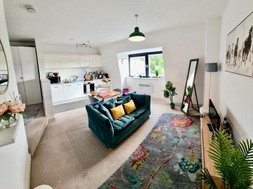uma sala de estar com um sofá azul e uma cozinha em Apartment in central Windsor em Windsor