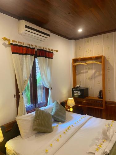 a bedroom with a large bed and a window at Golden Lotus Place in Luang Prabang