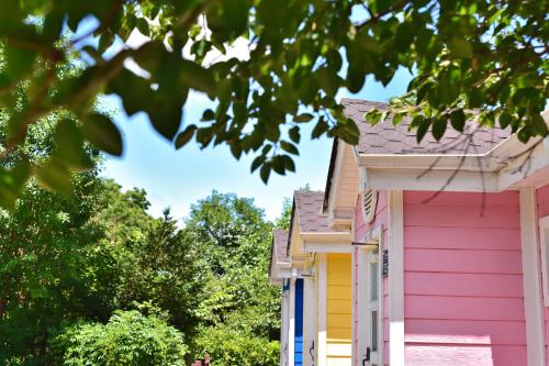 a pink and yellow house with trees in the foreground at Yangyang Pulbit Pension in Yangyang